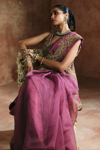 Seated view of the peach saree flowing over the knees with the gold border at the shoulder by Aman Takyar at Mrs. G