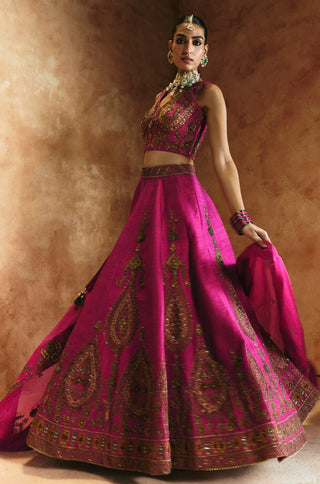 Three-quarter view of the rani pink lehenga with the organza dupatta lifted to one side by Aman Takyar at Mrs. G