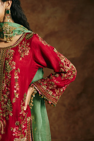 Close-up of the red kurta's gold-embroidered sleeve and neckline with floral motifs by Aman Takyar at Mrs. G