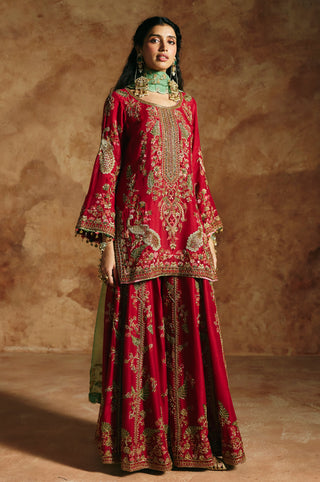 Front view of the red kurta with scooped neckline and bell sleeves over the wide sharara by Aman Takyar at Mrs. G