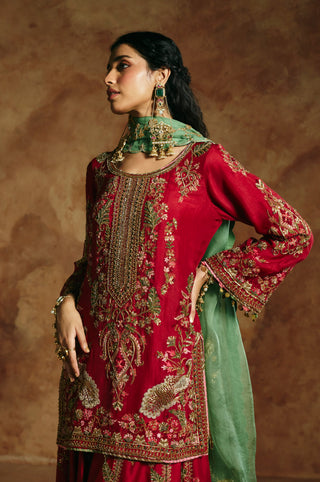 Side profile of the red kurta showing gold sleeve edging and the sea-green dupatta by Aman Takyar at Mrs. G