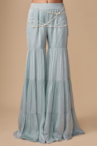 Close-up of the three-tier baby blue sharara with strands of pearls draped across the waist by Asaga at Mrs. G