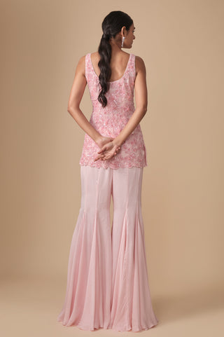 Full-length back view of the baby pink floral kurti with scooped back and gored satin sharara by Asaga at Mrs. G