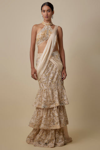Full-length front view of the beige pre-draped saree with three tiers of gold cutwork and a halter blouse by Asaga at Mrs. G