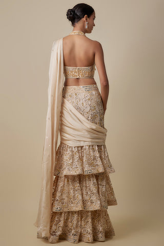 Full-length back view of the beige open-back halter blouse over the tiered gold cutwork skirt by Asaga at Mrs. G