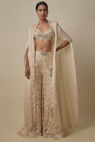 Full-length front view of the beige sharara set with a floor-length cape and paisley embroidered pants by Asaga at Mrs. G