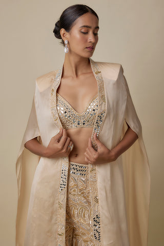 Waist-up view of the beige cape with structured shoulders open over a mirror-work blouse by Asaga at Mrs. G