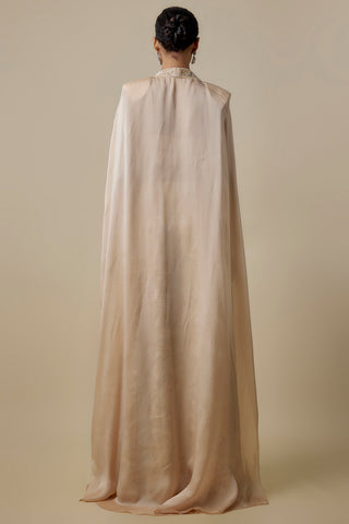 Full-length back view of the beige satin cape with structured shoulders falling to the floor by Asaga at Mrs. G
