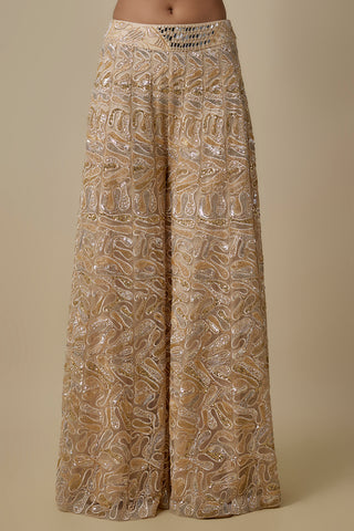 Close-up of the wide-leg beige sharara with gold and silver paisley embroidery and a mirror patch by Asaga at Mrs. G