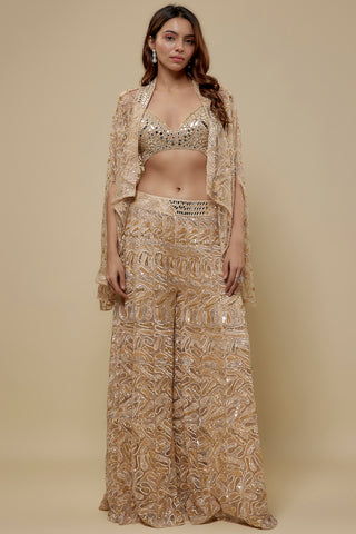 Front view of a beige mirror work blouse, sheer gold embroidered cape and wide-leg embroidered sharara by Asaga at Mrs. G
