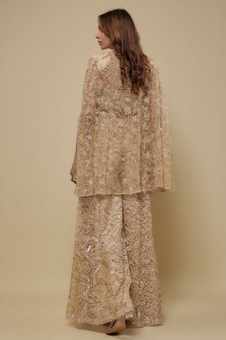 Back view of the beige tulle cape over the gold embroidered sharara by Asaga at Mrs. G