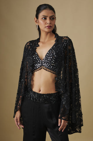 Waist-up view of the black mirror work V-neck blouse under a sheer net cape with flared sleeves by Asaga at Mrs. G