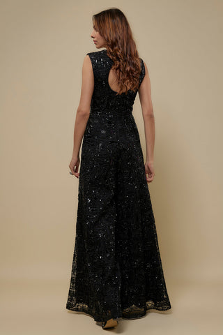 Back view of a black sleeveless wide-leg jumpsuit with abstract dori embroidery and a waist cutout by Asaga at Mrs. G