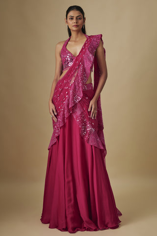 Front view of a fuchsia pre-draped saree with a mirror work halter blouse and ruffled net pallu by Asaga at Mrs. G