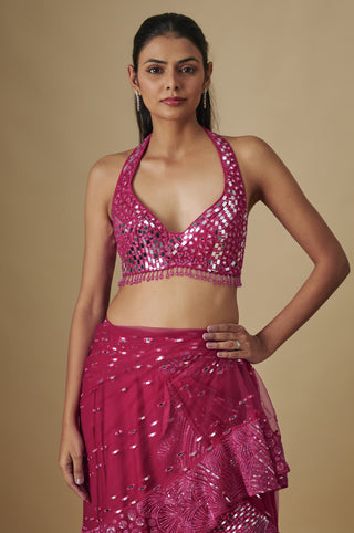 Waist-up view of the fuchsia halter blouse with mirror work and a bead fringe over a layered skirt by Asaga at Mrs. G