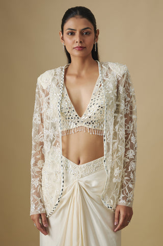 Waist-up view of the ivory long-sleeved net cape open over a mirror V-neck blouse by Asaga at Mrs. G