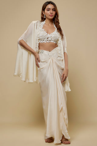 Front view of an ivory floral appliqué blouse and flowing cape over a satin drape skirt by Asaga at Mrs. G