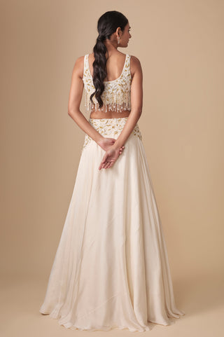 Full-length back view of the scooped back crop blouse with tassel fringe above the flowing satin lehenga by Asaga at Mrs. G