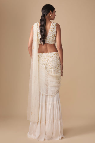 Full-length back view of the deep V back blouse with the net pallu falling from the shoulder over the tiered sharara by Asaga at Mrs. G