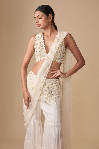 Three-quarter view of the floral blouse, wide embroidered waistband and beaded drops along the net pallu edge by Asaga at Mrs. G