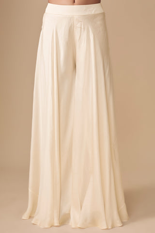 Close-up of the plain wide-flare ivory satin sharara on a flat waistband by Asaga at Mrs. G