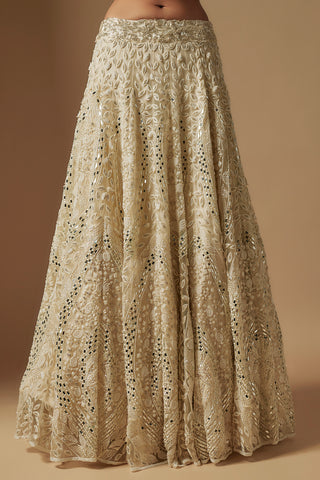 Waist-down view of ivory lehenga skirt with leaf appliqué and scattered mirrors by Asaga at Mrs. G
