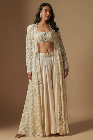 Front view of ivory evoke mirror work blouse, wide-leg sharara and sheer floor-length floral jacket by Asaga at Mrs. G