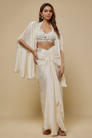 Front view of an ivory floral appliqué blouse and flowing cape over a satin drape skirt by Asaga at Mrs. G