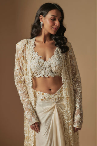 Waist-up close-up of ivory floral appliqué V-neck blouse under an embroidered sheer jacket by Asaga at Mrs. G