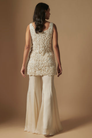 Back view of ivory short kurti with leaf appliqué and wide flared sharara by Asaga at Mrs. G