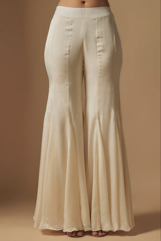 Waist-down view of ivory paneled satin sharara with a smooth waistband by Asaga at Mrs. G