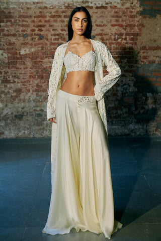 Front view of the ivory long jacket worn open over a leaf-embroidered blouse and flared satin sharara by Asaga at Mrs. G
