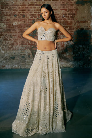 Front view of the ivory tulle lehenga with mirror embroidery and a sweetheart bustier by Asaga at Mrs. G