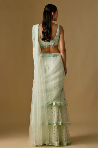 Back view of the mint saree's deep scoop blouse back and the net pallu trailing over the tiered skirt by Asaga at Mrs. G