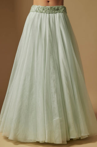 Waist-down view of the mint flared skirt with a floral appliqué waistband by Asaga at Mrs. G