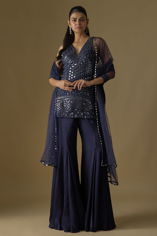 Front view of a navy blue mirror work kurti with a net dupatta over a flared satin sharara by Asaga at Mrs. G
