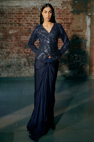 Front view of a navy blue sequin jacket with a knotted satin organza drape skirt by Asaga at Mrs. G