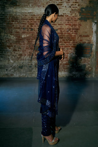 Side view of the navy blue short kurta, slim pants and the net dupatta draped over the shoulders by Asaga at Mrs. G