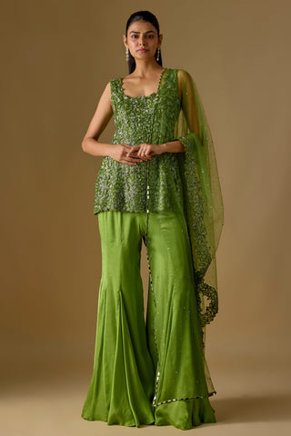 Full-length front view of the olive green short kurti with leaf appliqué over a flared satin sharara by Asaga at Mrs. G
