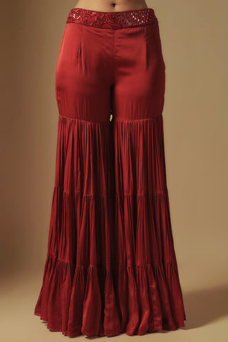 Waist-down view of red tiered sharara with a mirror and embroidery waistband by Asaga at Mrs. G
