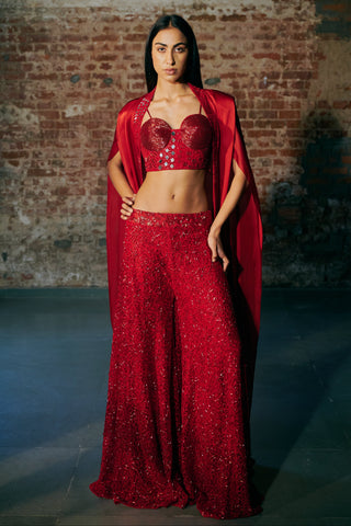 Front view of a red corset sharara set with a long satin organza cape worn open by Asaga at Mrs. G