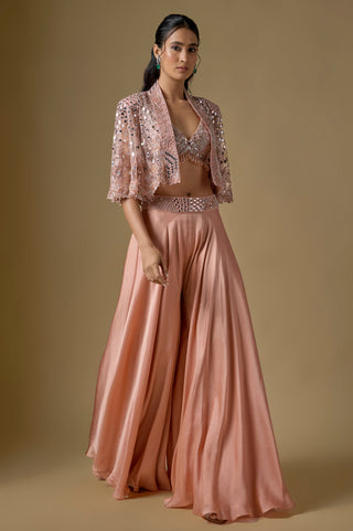 Full-length front view of the rose gold short mirror cape over a bralette blouse and wide-leg satin sharara by Asaga at Mrs. G
