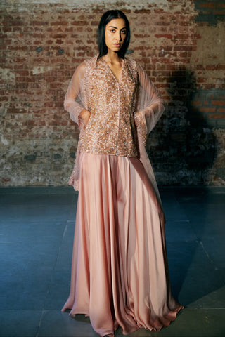 Front view of the rose gold jacket sharara set with the net dupatta draped over both arms by Asaga at Mrs. G