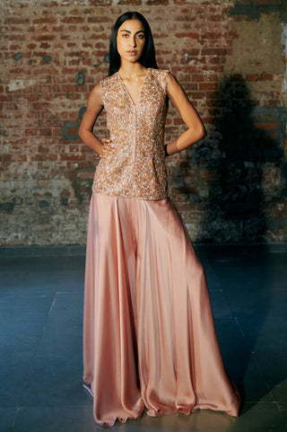 Front view of the rose gold jacket top and satin sharara with the model standing with hands on hips by Asaga at Mrs. G
