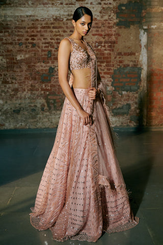 Three-quarter view of the rose gold lehenga with the feather-trim dupatta falling across the flared skirt by Asaga at Mrs. G