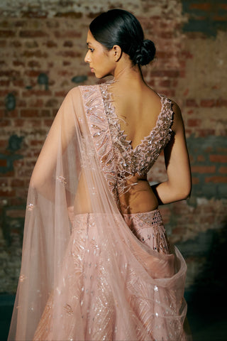 Back view of the rose gold blouse's deep V back with the sheer dupatta draped over the arm by Asaga at Mrs. G