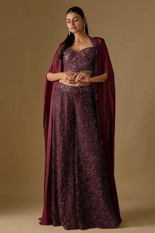 Full-length front view of the wine mirror work corset and tonal embroidered sharara under a long satin cape by Asaga at Mrs. G