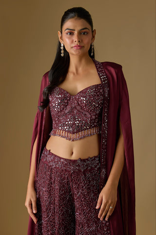 Waist-up close-up of the wine sweetheart corset with mirror work and a bead fringe, framed by the open cape by Asaga at Mrs. G