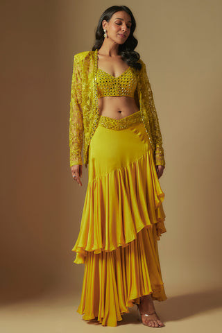 Front view of yellow umble mirror work blouse, sheer jacket and tiered satin drape skirt by Asaga at Mrs. G