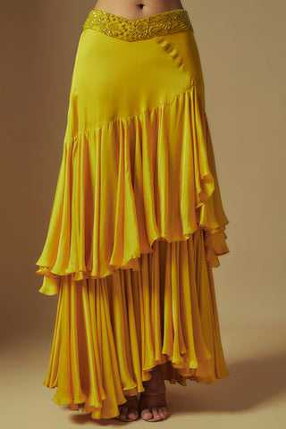 Waist-down view of yellow asymmetric tiered drape skirt with an embroidered V waistband by Asaga at Mrs. G
